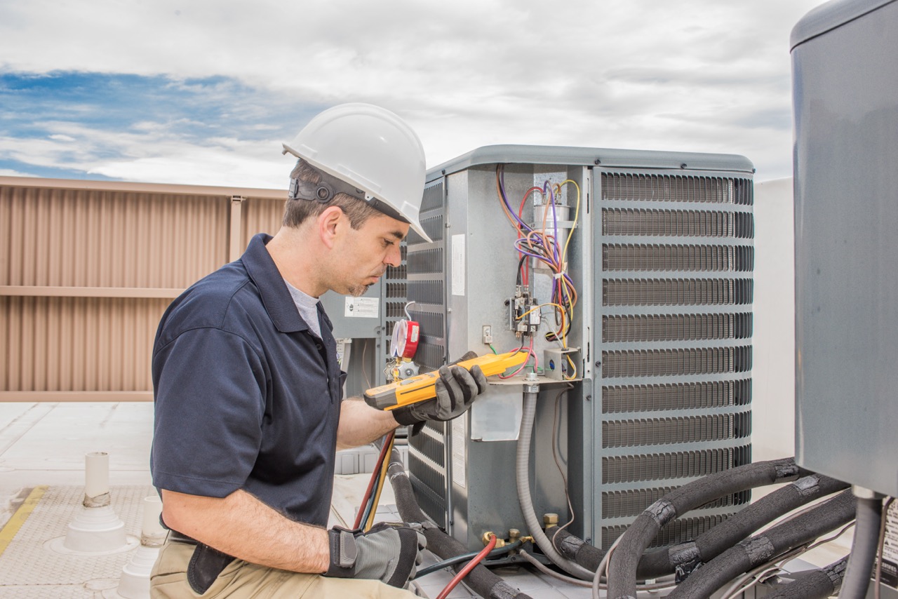HVAC technician diagnosing AC unit